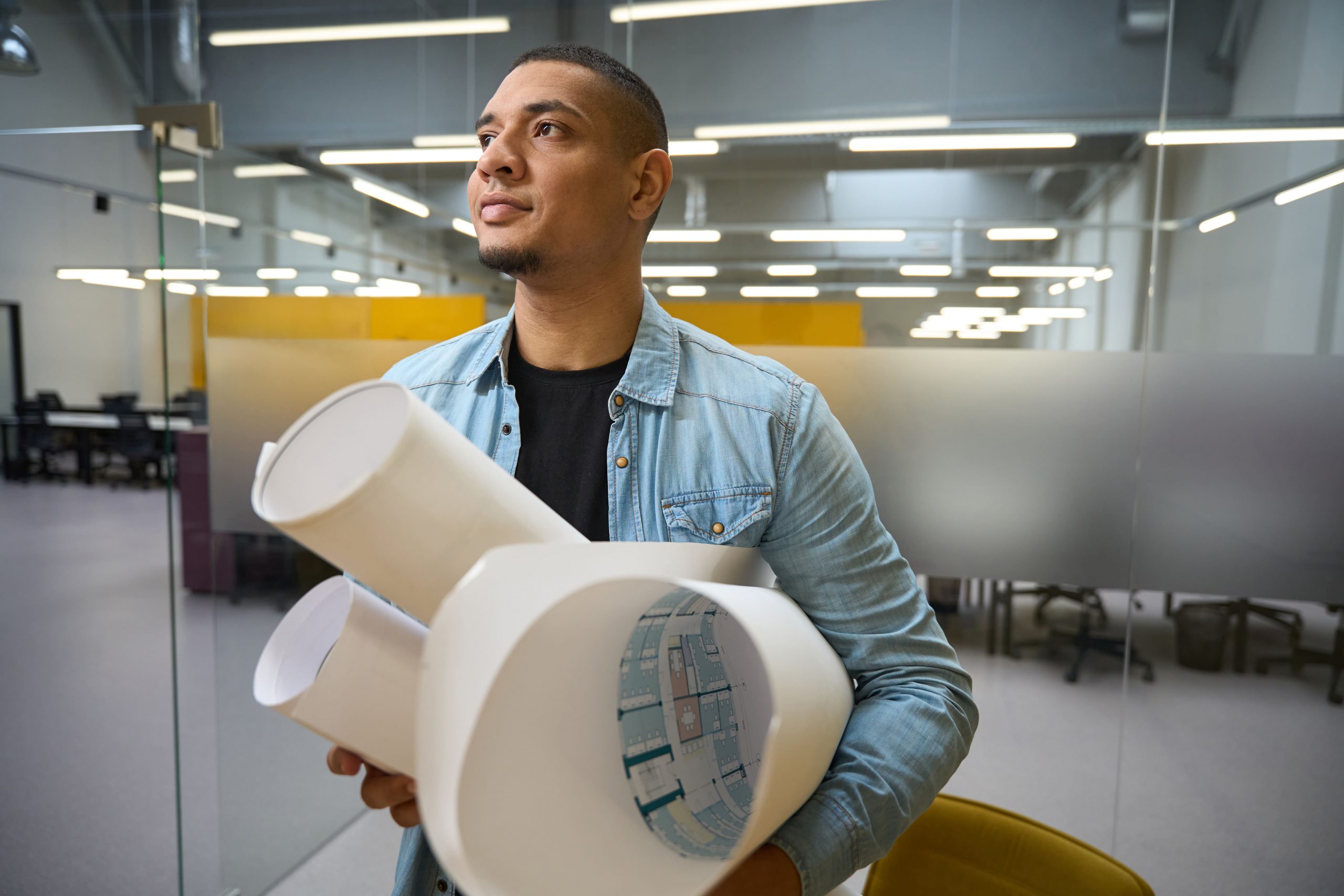 Copia de smiling-young-architect-standing-and-holding-rolle-2024-10-19-22-20-00-utc